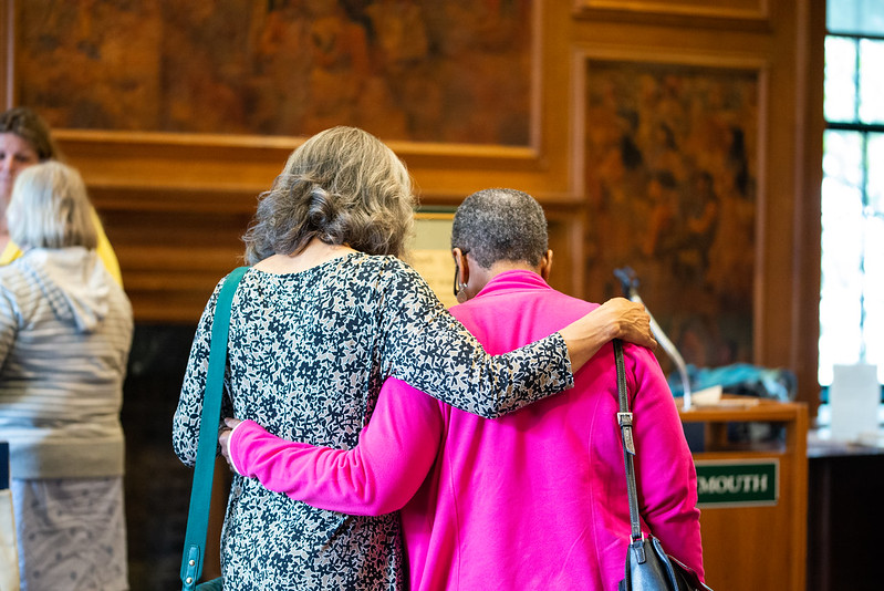 Two women arm in arm at an alumni event